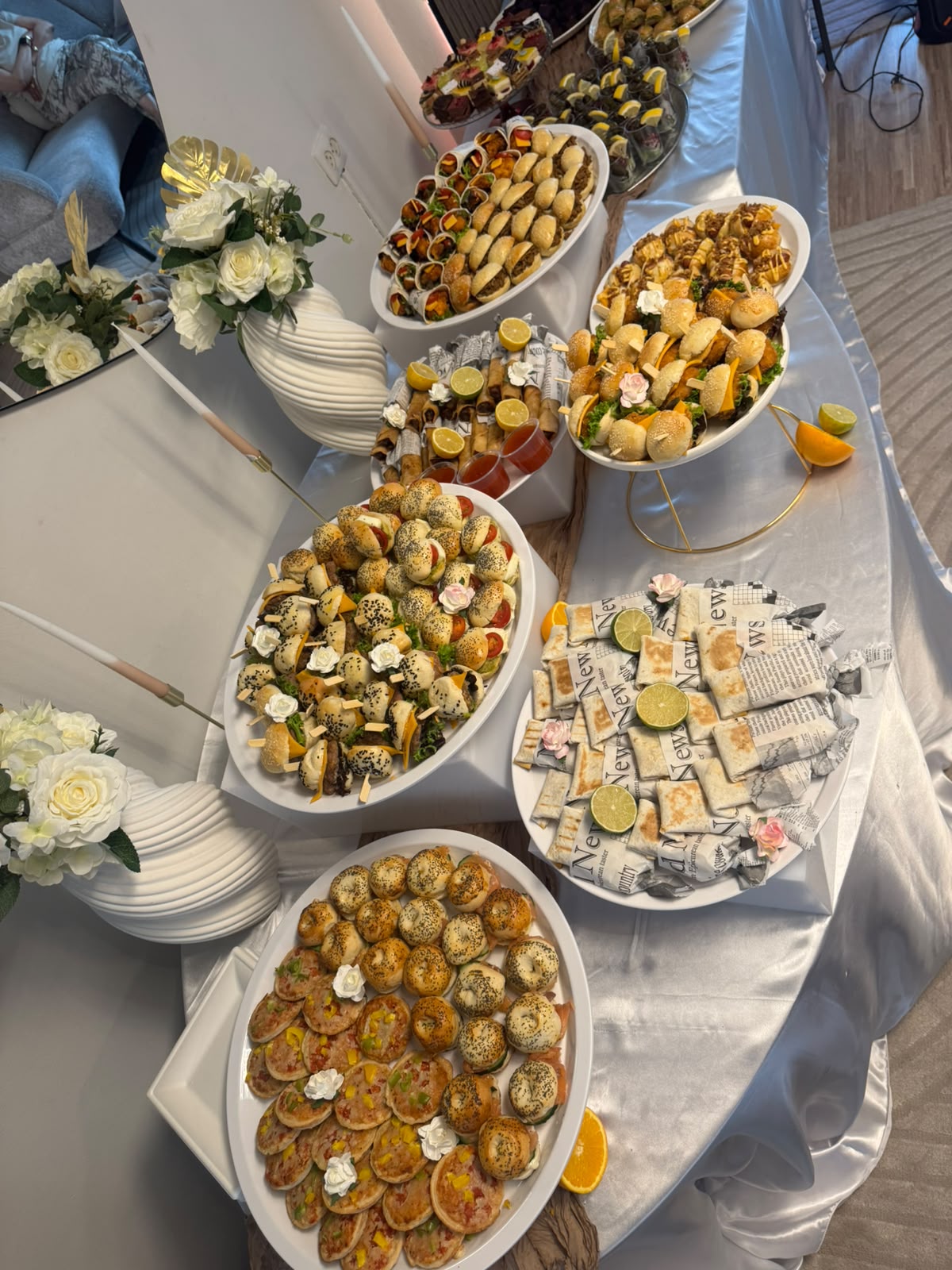 Buffettafel met witte rozen en schalen vol mini hapjes