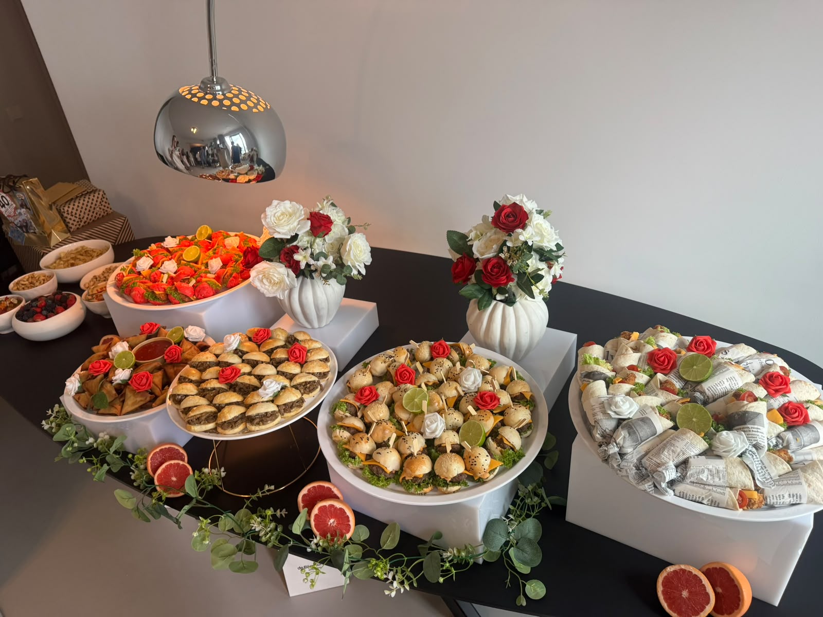 Overzicht van een opgebouwd buffet met bloemen en serveerschalen