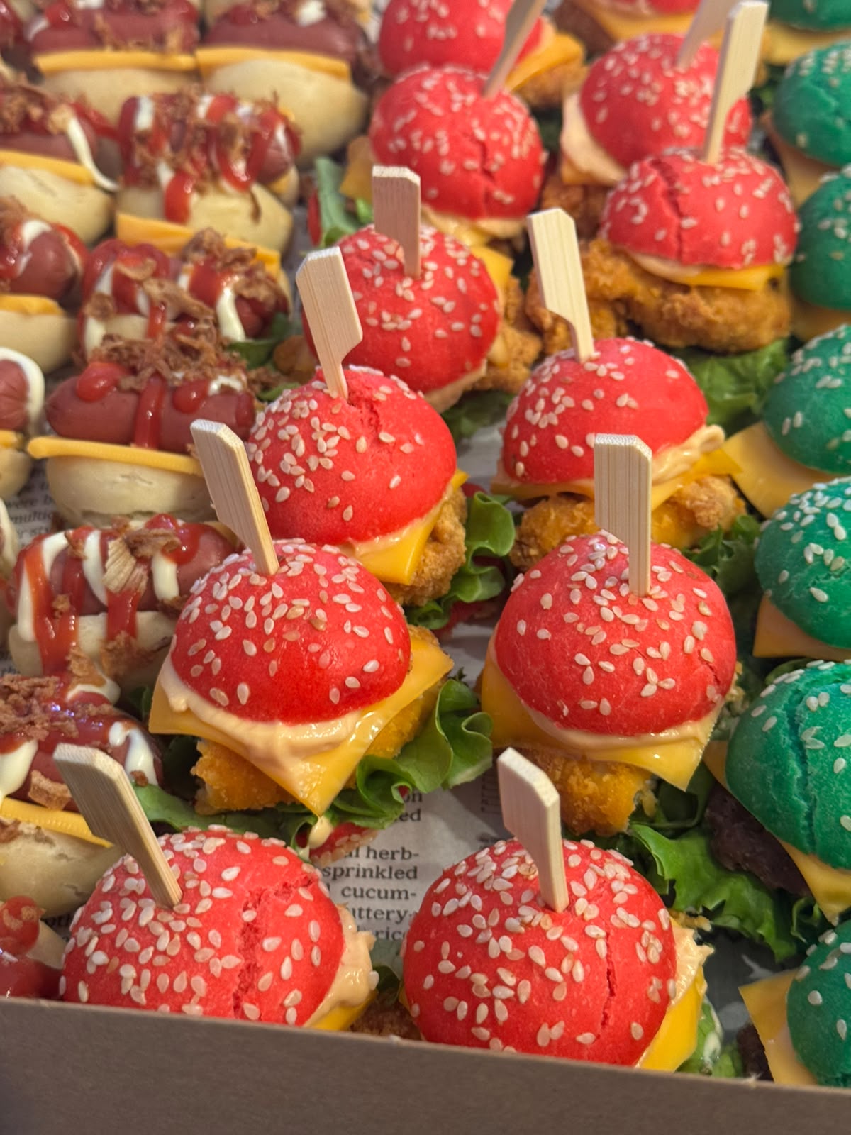 Schaal met rode en groene mini burgers op prikkers