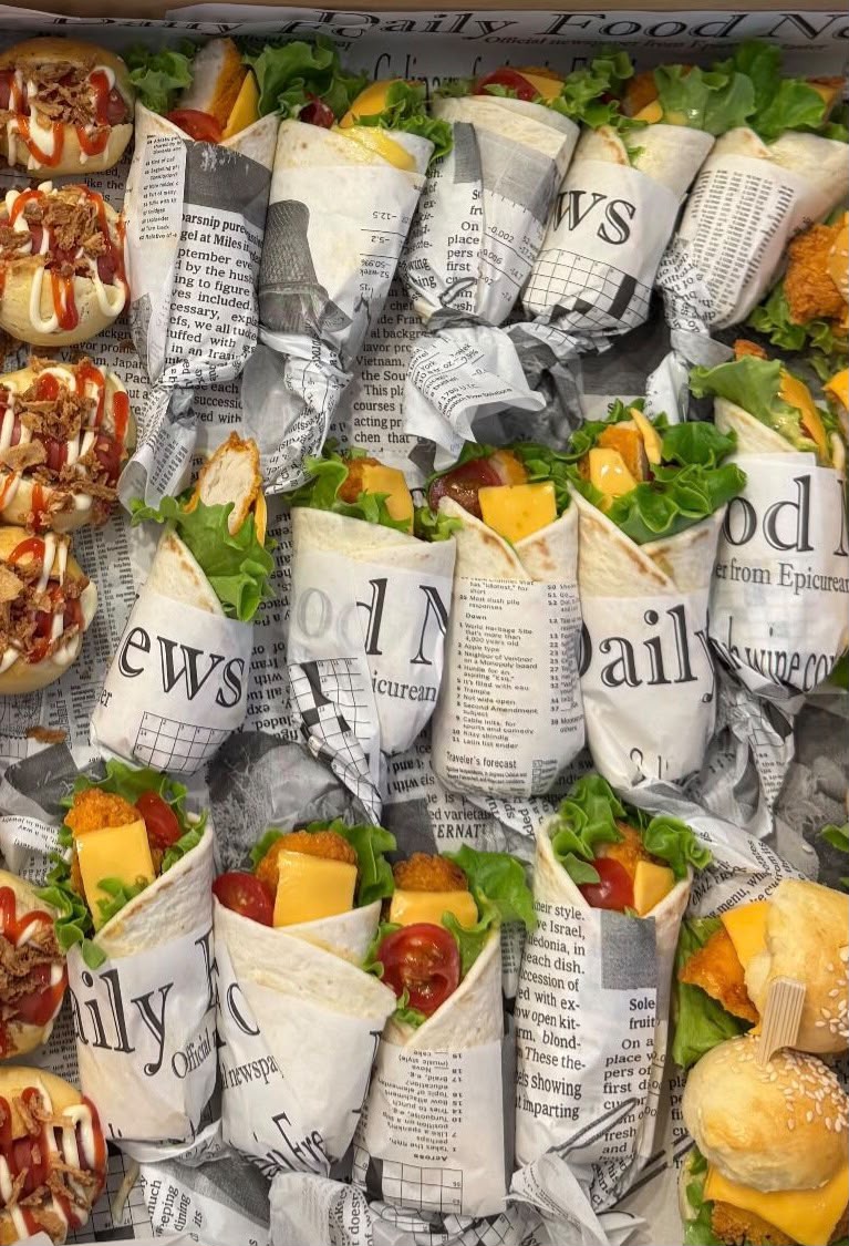 Wraps in krantenpapier met kaas, sla en tomaat