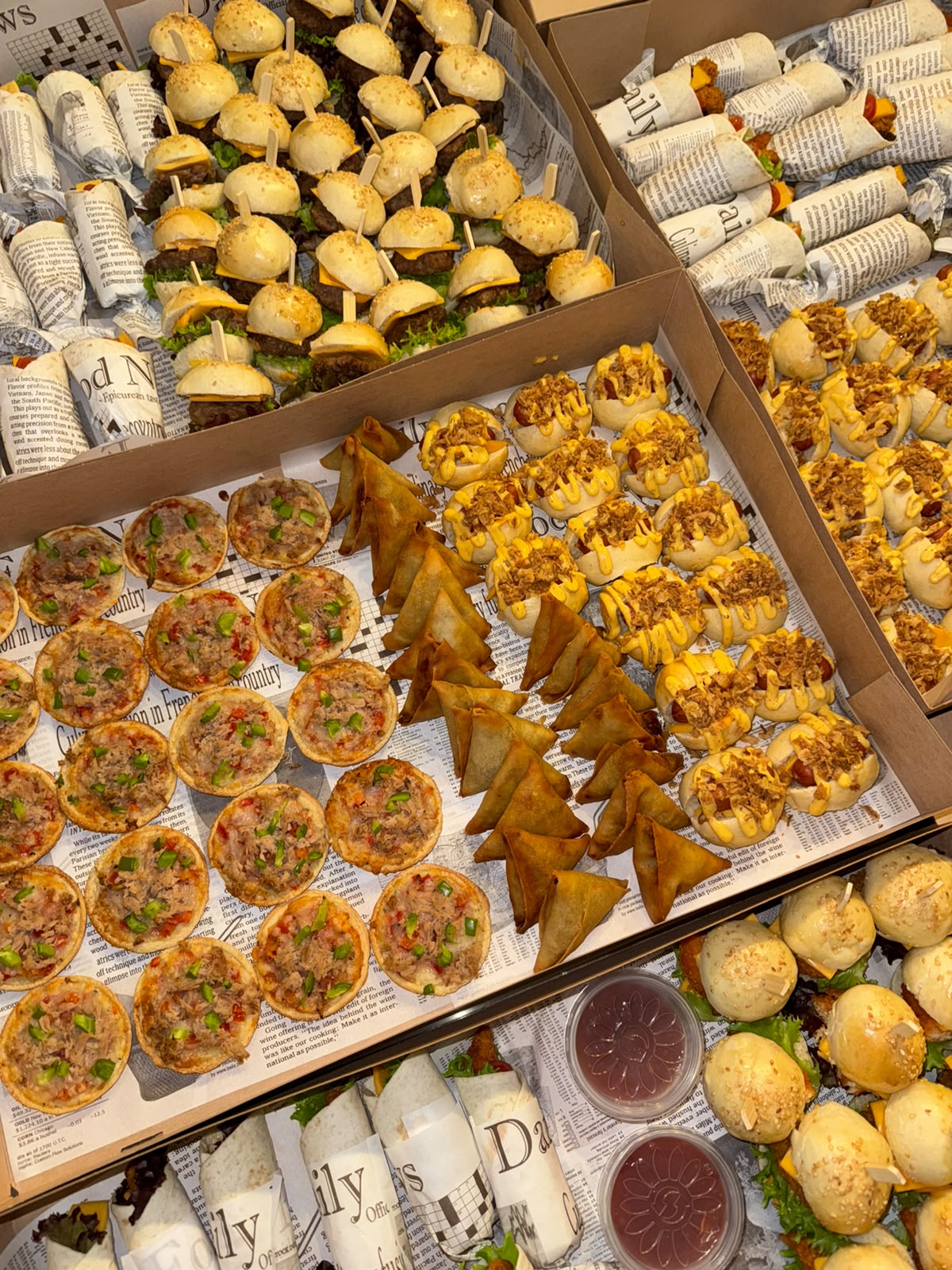 Cateringboxen met mini quiches, samosa en gevulde broodjes