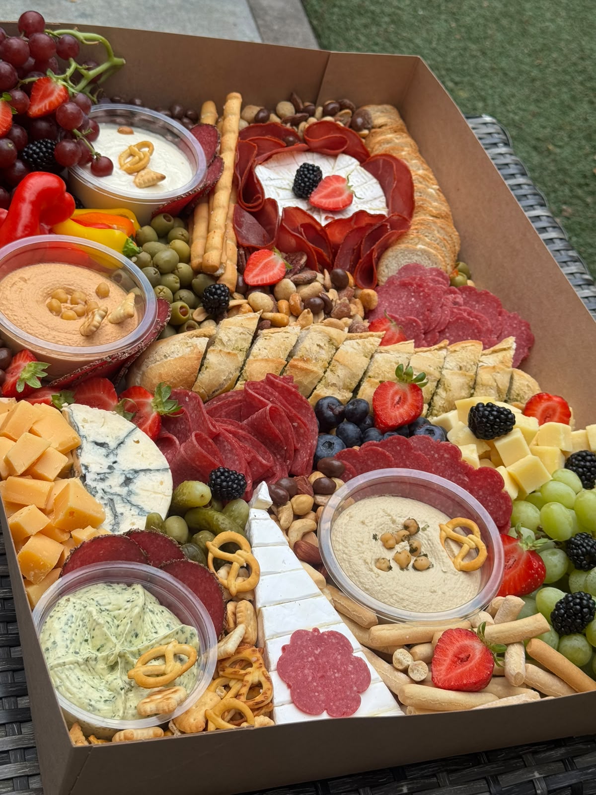 Grazingbox met brie, charcuterie, dips, noten en vers fruit