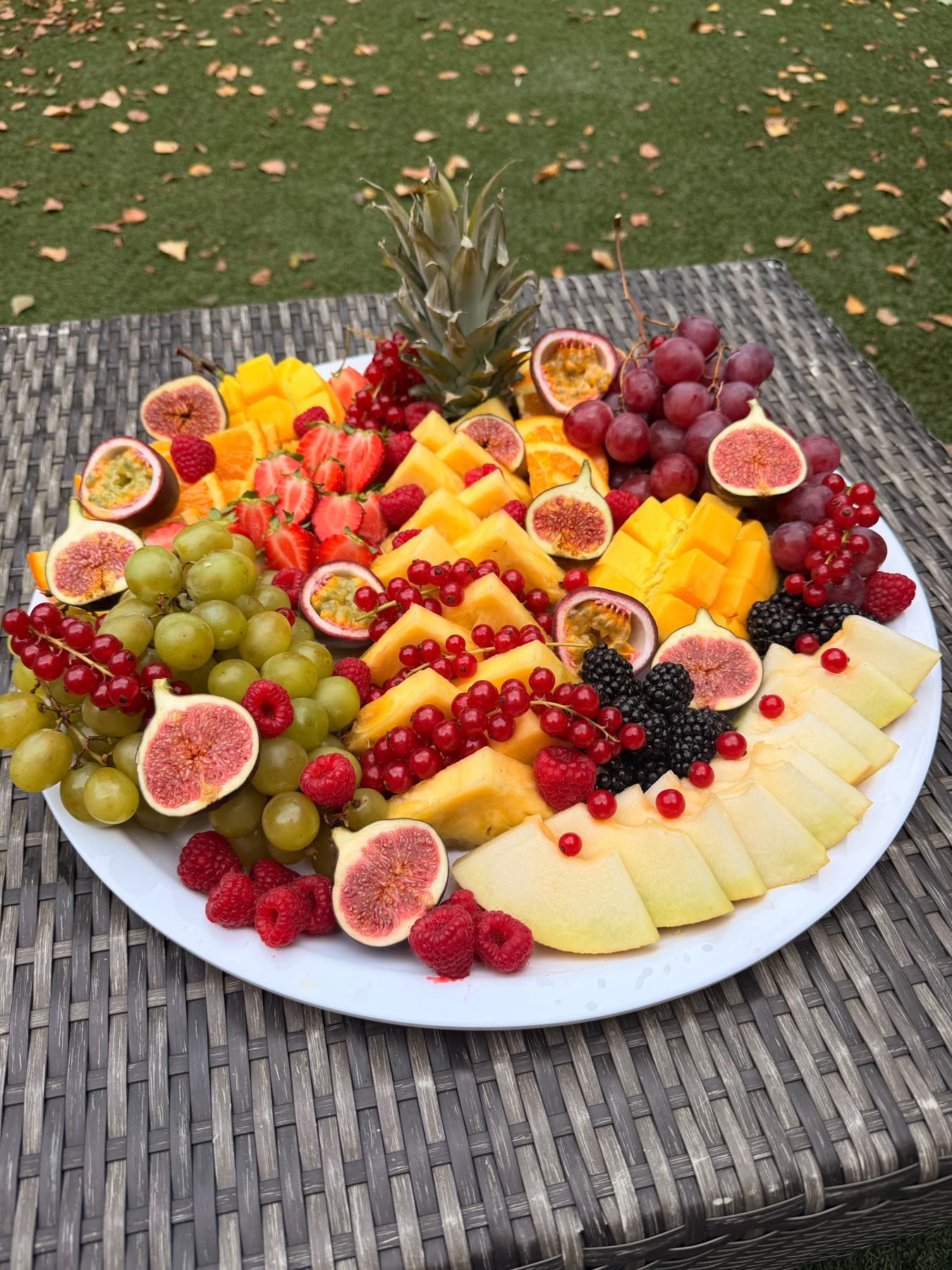 Grote fruitschaal met ananas, mango, vijgen en bessen
