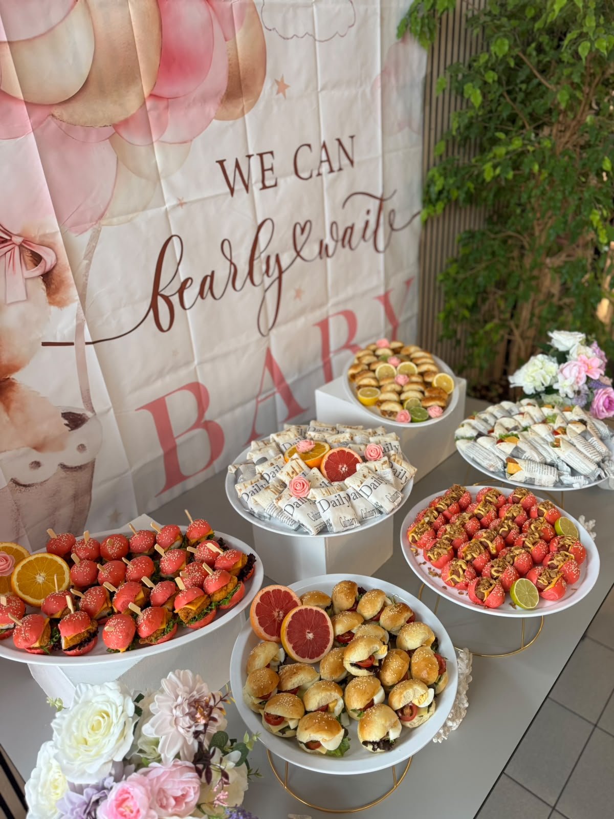 Gestyled babyshowerbuffet met witte schalen en bloemen